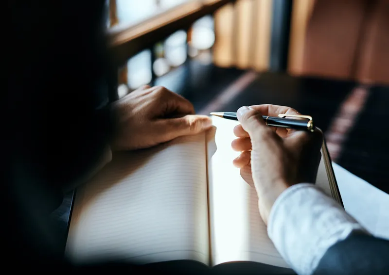 Бизнесвумен в кафе с книгой на столе, документами и чашкой кофе