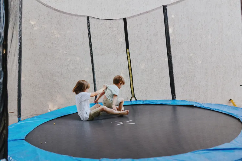 Happy children jumping on a trampoline, enjoying playful moments, laughter, and energy in a sunny outdoor setting. Perfect for summer fun and joy.