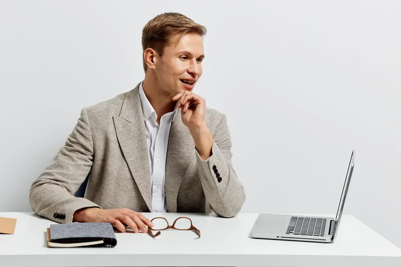 young man working with laptop smile look side casual jacket office table digital nomad remote work technology concept
