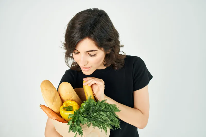 Брюнетка с пакетом продуктов из супермаркета