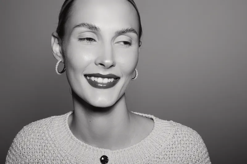 Happy Caucasian woman with fair skin smiles with eyes closed in black and white portrait. Concept for beauty, emotion, and positive mood.