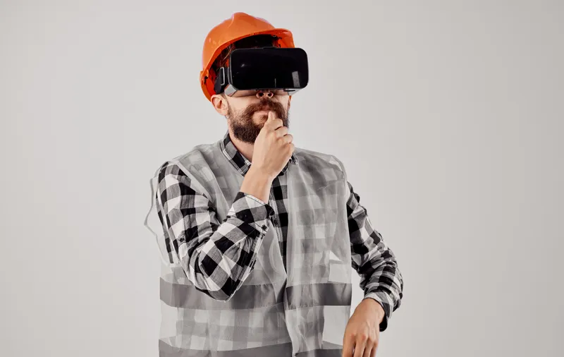 Инженер-строитель в 3D-очках виртуальной реальности и оранжевой каске на голове
