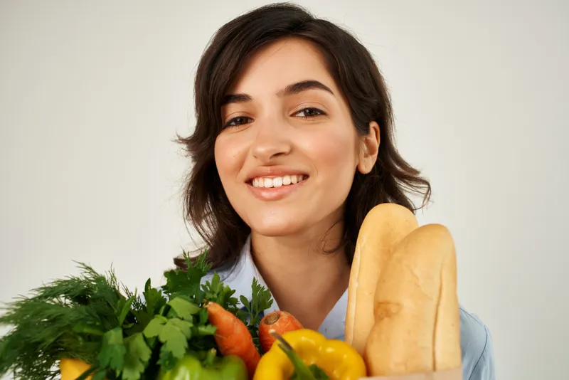 Весёлая женщина с пакетом продуктов, овощей, здоровой еды, доставка еды