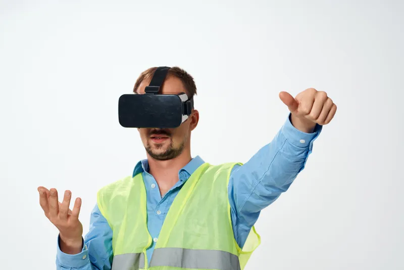 Мужчина в строительной униформе и VR-очках, олицетворяющий работу инженера