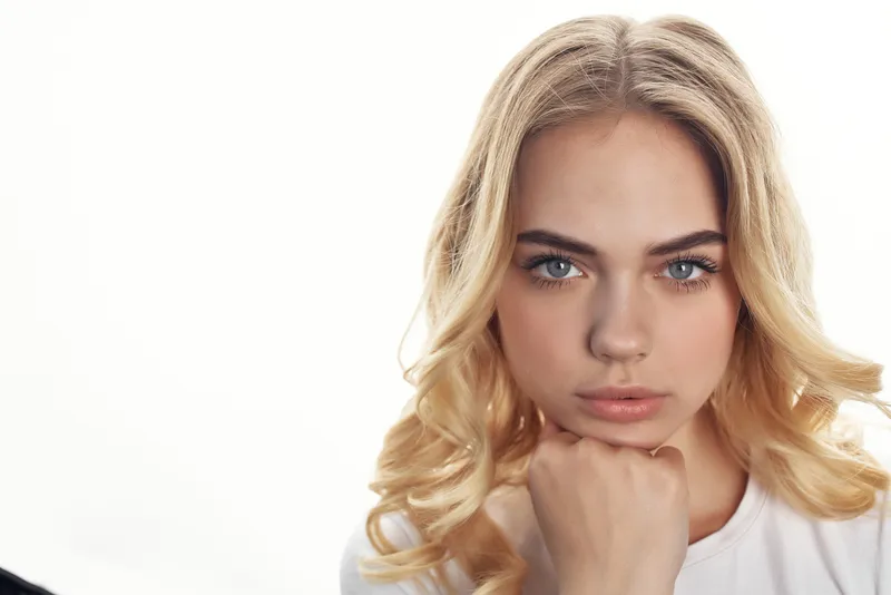 Симпатичная женщина с привлекательным взглядом и прической на светлом фоне