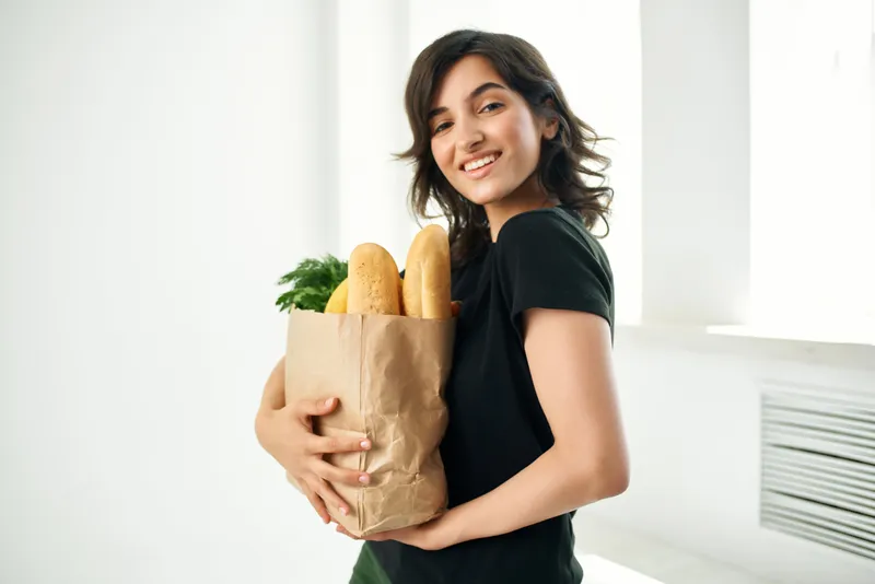 Женщина на кухне с пакетом продуктов готовит еду, доставка еды, здоровье