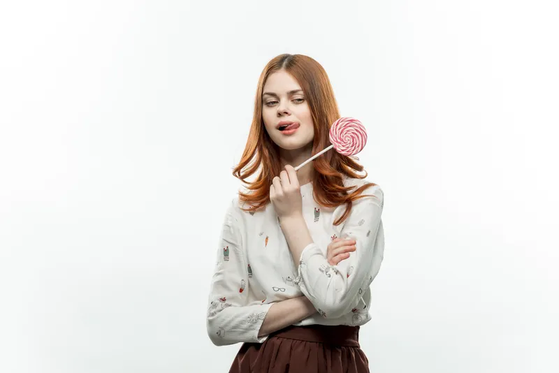 Весёлая женщина облизывает леденец — радость, сладости, эмоции