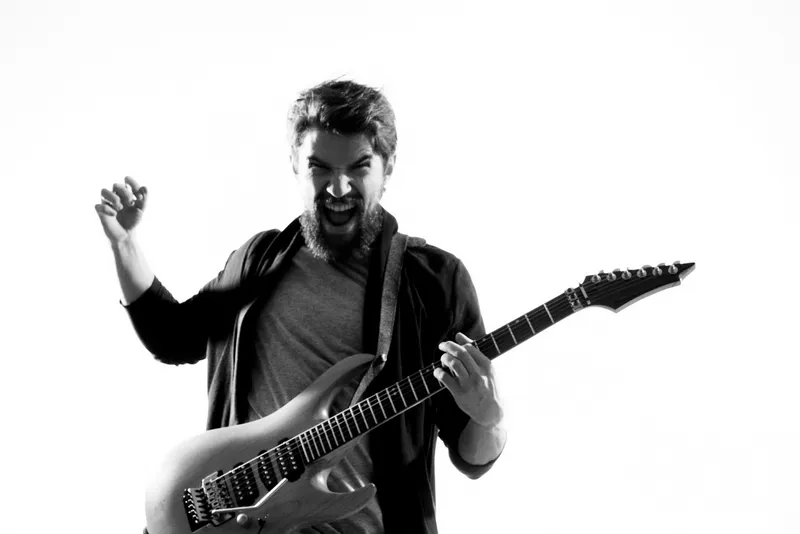 Мужчина-музыкант с гитарой, рок-звезда, исполняет развлекательную программу