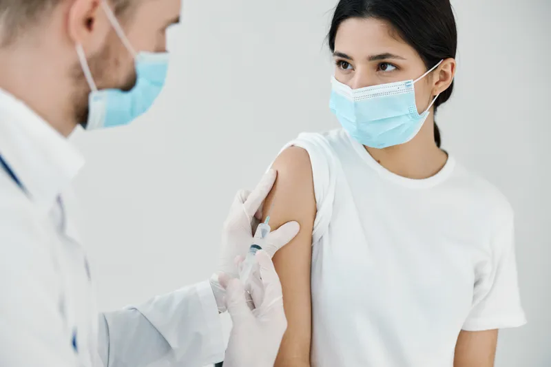 Пациент в медицинской маске в больнице и врач, вакцинация, инъекция
