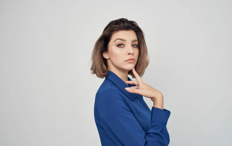 Веселая женщина в полосатой футболке и двойных очках улыбается
