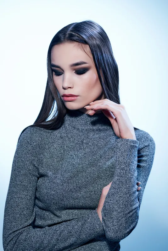 Женщина с ярким макияжем позирует, кадр обрезан
