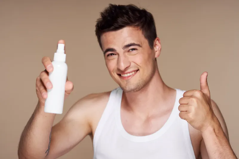 Мужчина с банкой в руке улыбается и показывает большой палец
