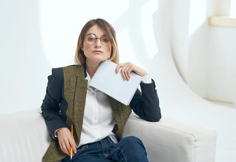 Женщина сидит на стуле с бумагами в руках, резюме, работа в офисе