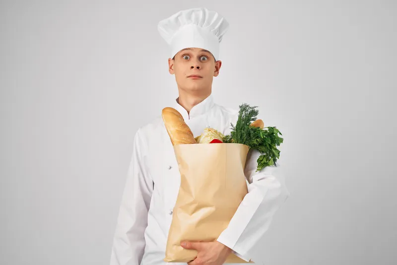 Мужчина в форме повара держит упаковку с продуктами, работа в ресторане