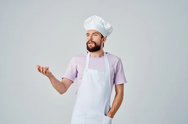 Эмоциональный шеф-повар-мужчина работает на кухне ресторана