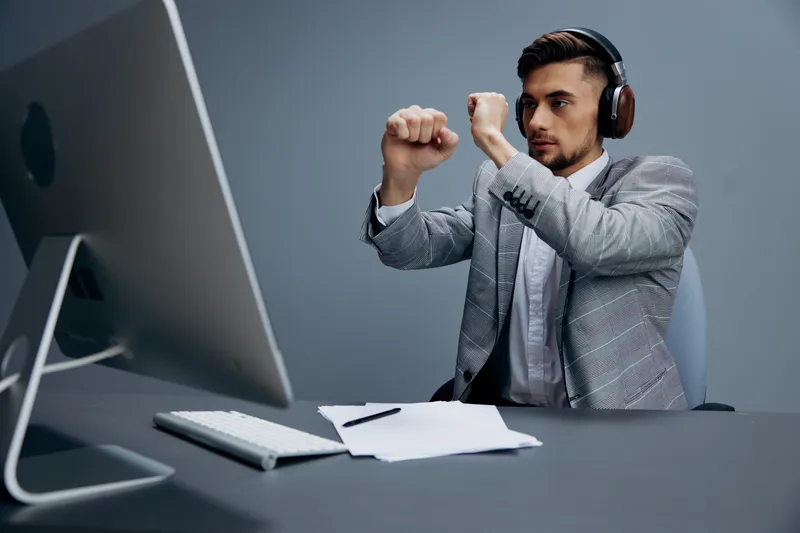 Менеджер работает за компьютером в наушниках в офисе