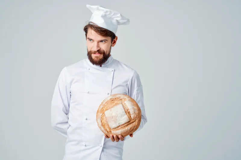 Мужчина-повар занимается выпечкой, демонстрируя профессиональные эмоции