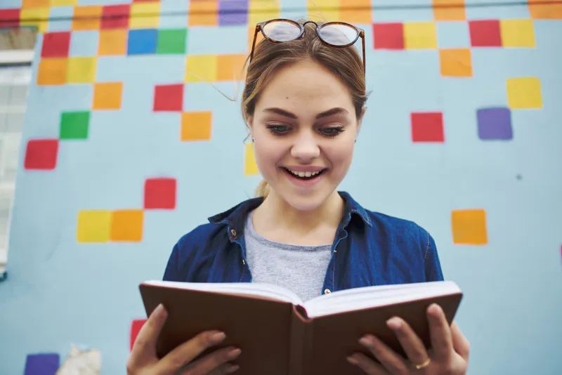 Симпатичная женщина на открытом воздухе с книгой в руках, свежий воздух, образ жизни