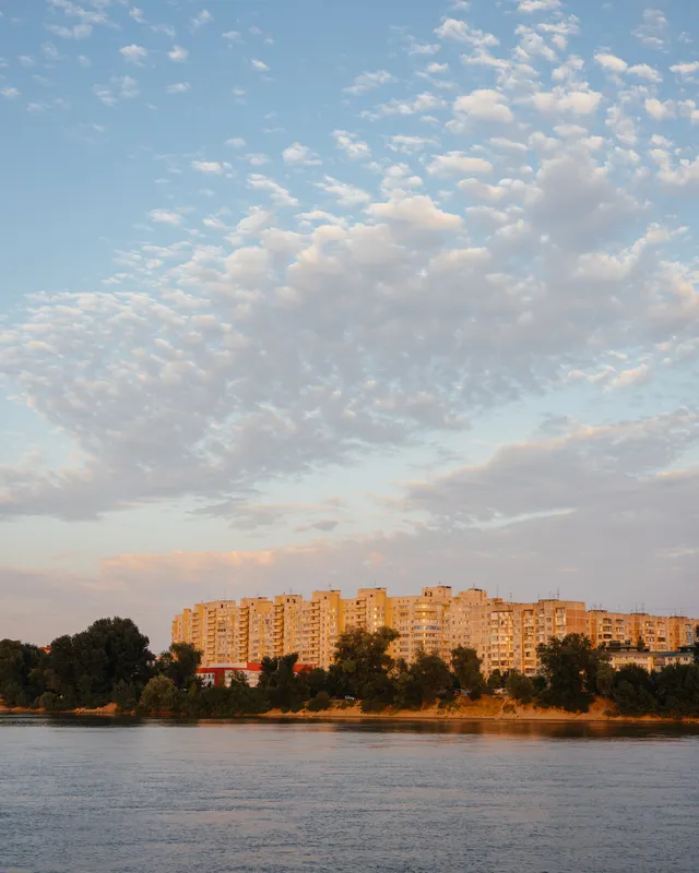 Облака, небольшая река, свежий воздух, многоэтажное здание на природе