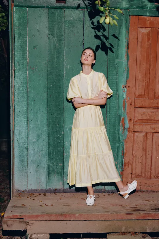 Woman in yellow dress by rustic wall authenticity inclusive