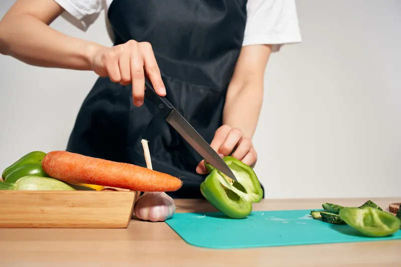 Повар на кухне нарезает овощи, работа по дому, витамины