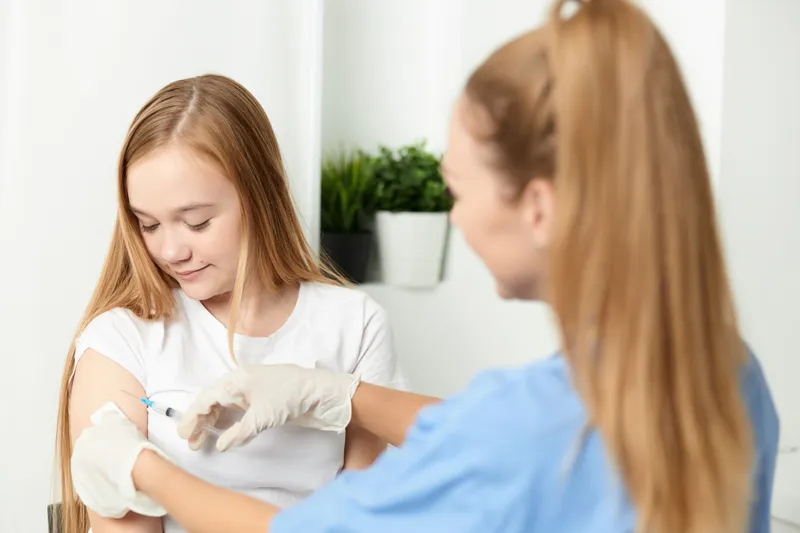 Женщина-врач делает инъекцию в руку девушки, вакцинация, здоровье