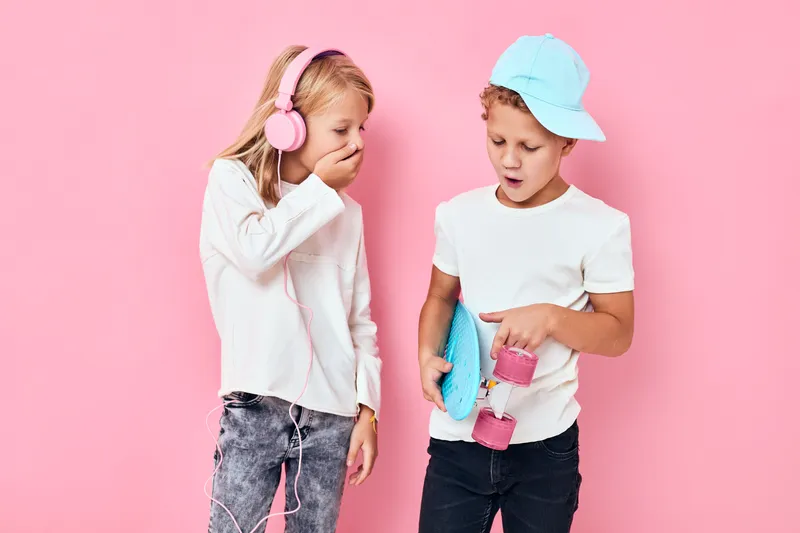 Портрет двух улыбающихся маленьких детей со счастливыми лицами на синем изолированном фоне