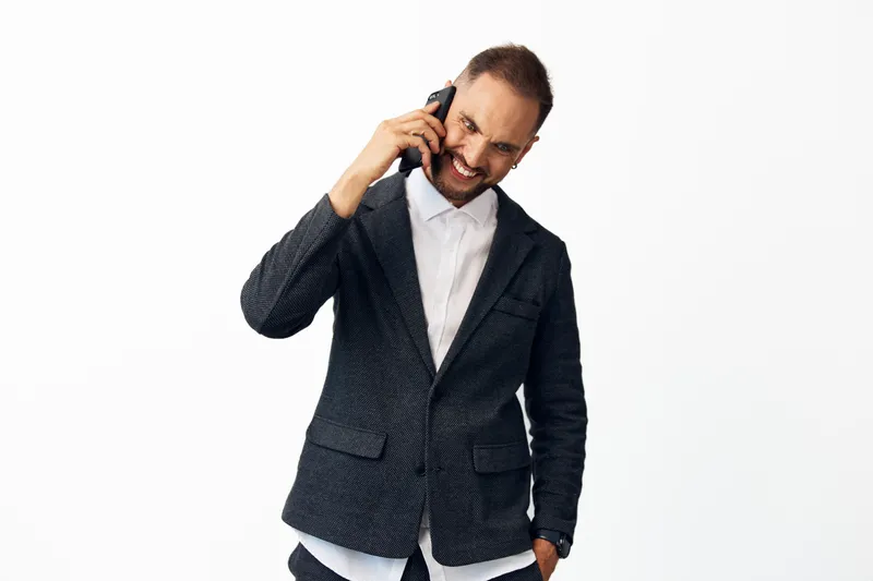 A confident business professional man on a call, smiling with focus and energy, isolated on a clean background, capturing emotion and strong workplace presence.