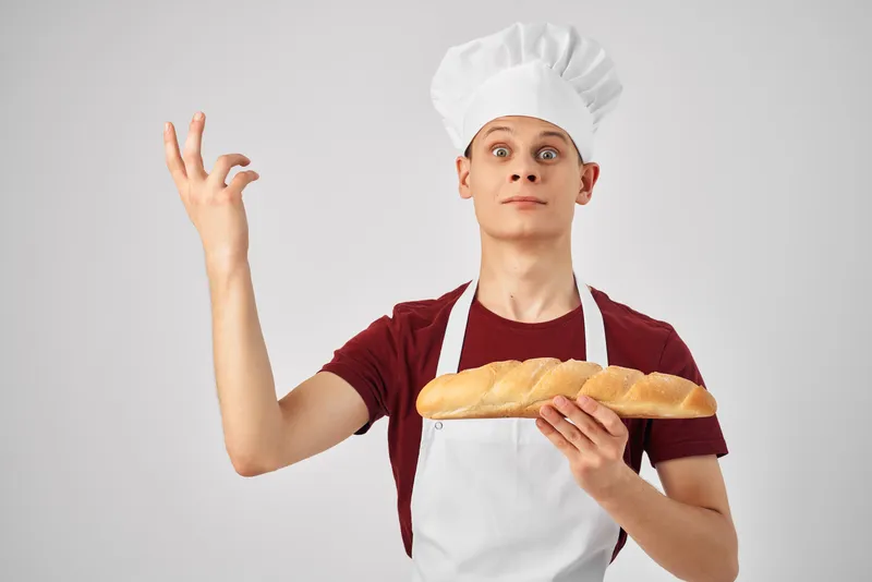 Повар-мужчина готовит и занимается выпечкой на кухне на светлом фоне