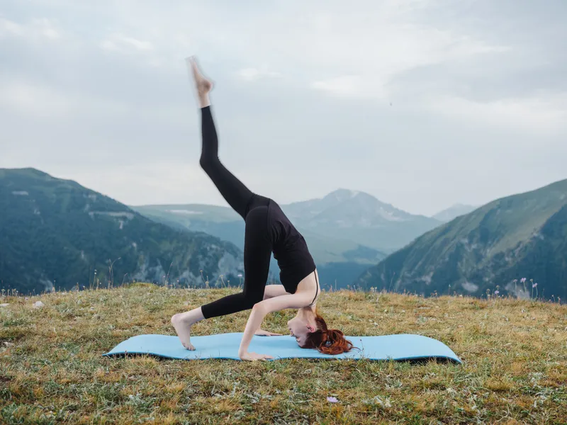 Спортивная женщина занимается йогой, медитацией и упражнениями в горах на открытом воздухе