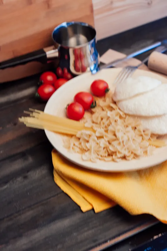 Ингредиенты для итальянской пасты на кухонном деревянном столе, процесс приготовления