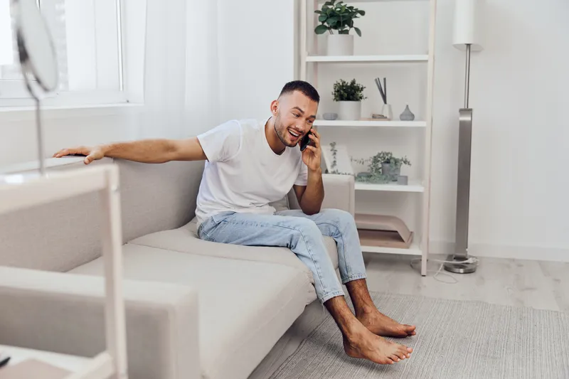 A man engaged in an emotional phone call, embodying vulnerability and connection during a digital detox at home, focused on well-being and mental health.