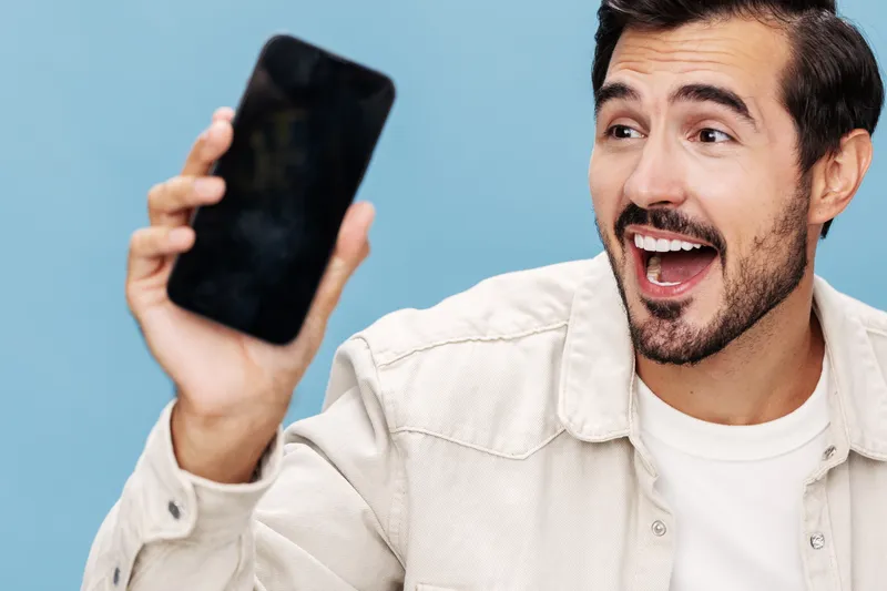 Портрет брюнета крупным планом, который показывает экран телефона в качестве макета