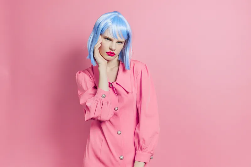 Гламурная женщина в синем парике и с макияжем на изолированном фоне