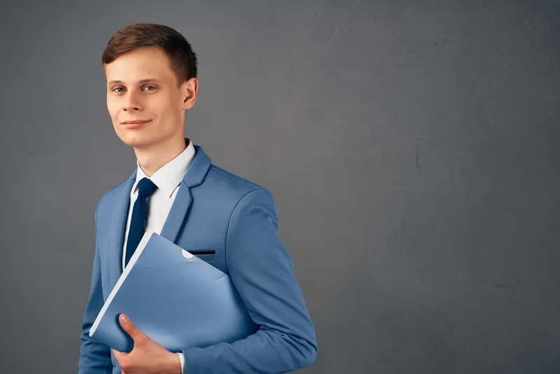Улыбающийся бизнесмен в костюме с документами на изолированном фоне
