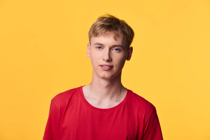 Man, young, red shirt, yellow background, studio lighting, casual headshot tone with a cheerful expression suitable for fashion, branding, advertising, marketing and lifestyle campaigns