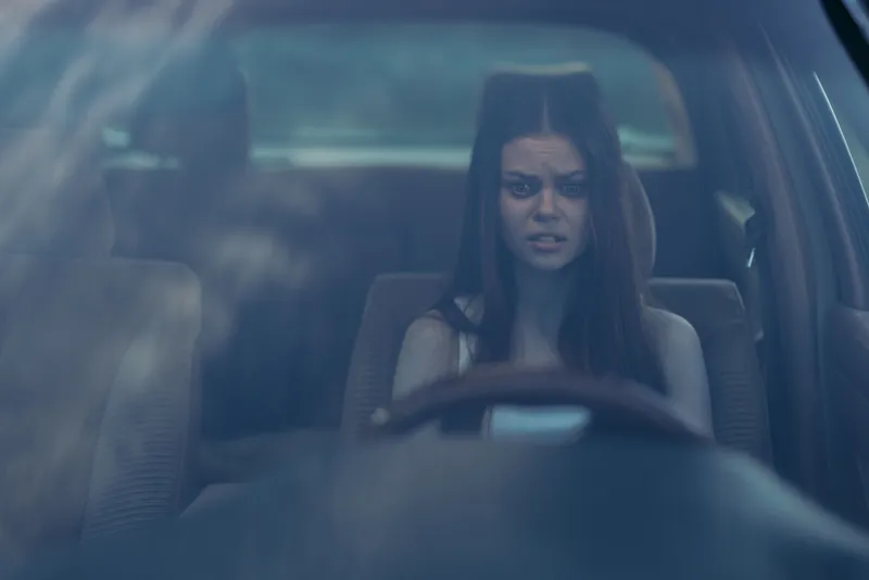 Concerned young woman driving a car, expressing anxiety and uncertainty, with soft natural light filtering through the window, creating an emotional and reflective atmosphere.