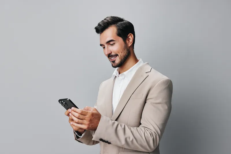 Мужчина улыбается и делает селфи на смартфон