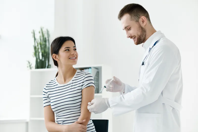 Врач-мужчина делает укол женщине, вакцинация, здоровье