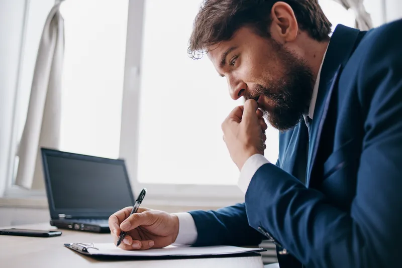 Менеджер работает за ноутбуком в офисе, эмоции, технологии