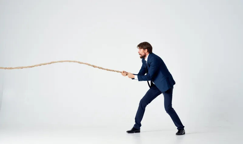 Мужчина в костюме тянет за веревку, карьера, офис, светлый фон