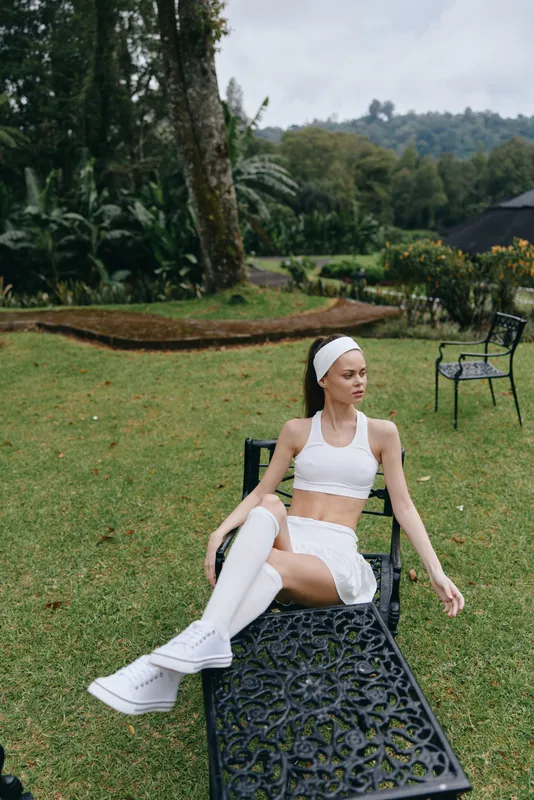 Fit young woman in sportswear enjoying nature, showcasing healthy lifestyle in a lush outdoor setting with a vibrant green palette, ideal for fitness concepts