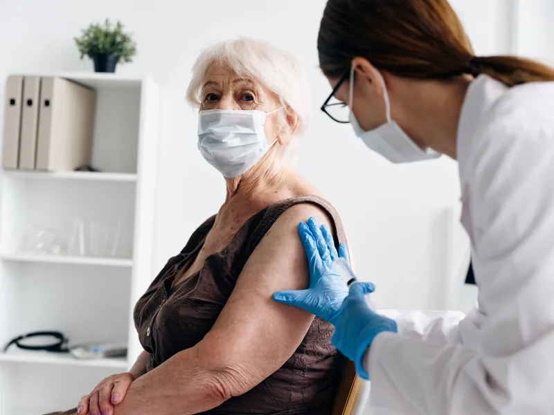 Врач и пациент обсуждают вакцинный паспорт COVID-19 в больнице