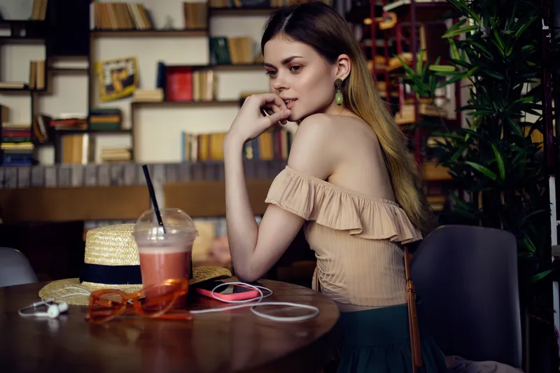 Красивая женщина читает книгу в кафе