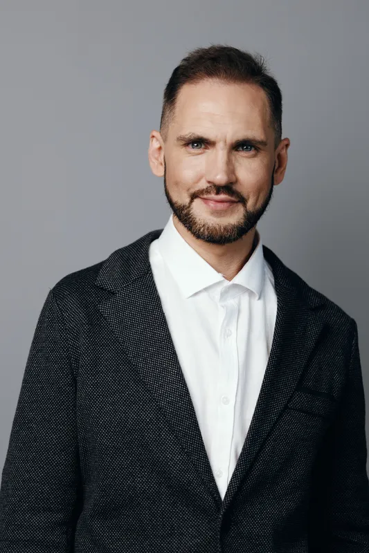 Professional man in business attire stands against an isolated colored background, exuding confidence and focus, ideal for leadership, corporate branding, and clear communication in media.