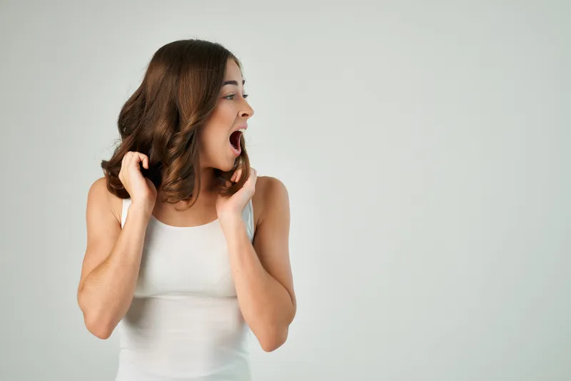 Весёлая брюнетка в белой футболке с модной причёской, студийная съёмка в стиле лайфстайл