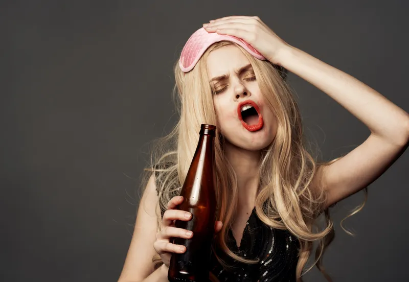 Пьяная женщина с бутылкой пива, ярким макияжем, блондинка в розовой маске для сна