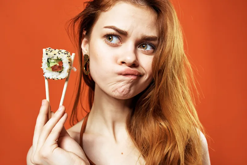 Женщина с палочками для еды, роллы суши, закуска в японском стиле