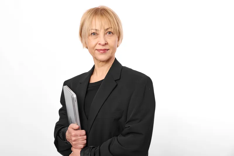 Confident business woman in black blazer holding a smartphone, studio portrait on white background, calm smile, upright posture, modern communication, clean minimal light
