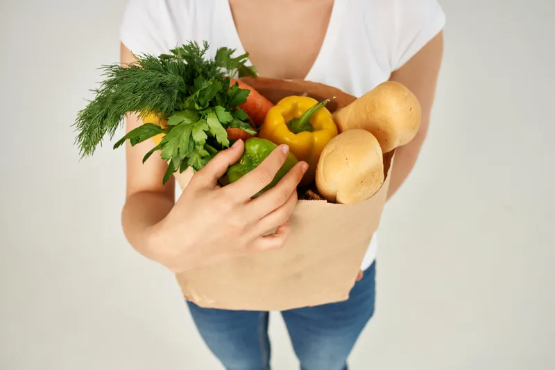 Крупный план бумажного пакета с продуктами, овощами